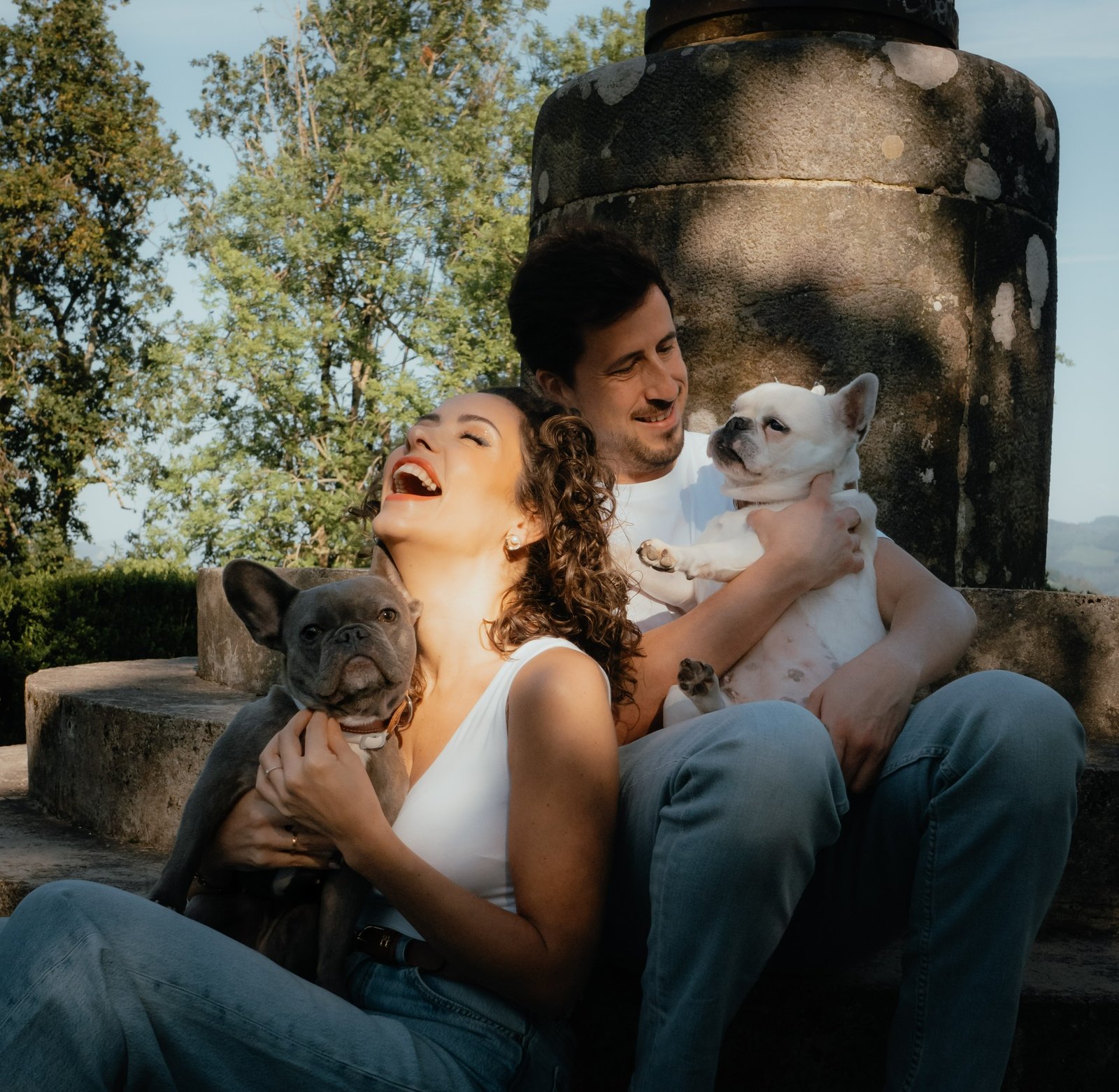 Una pareja riendo con sus dos perros