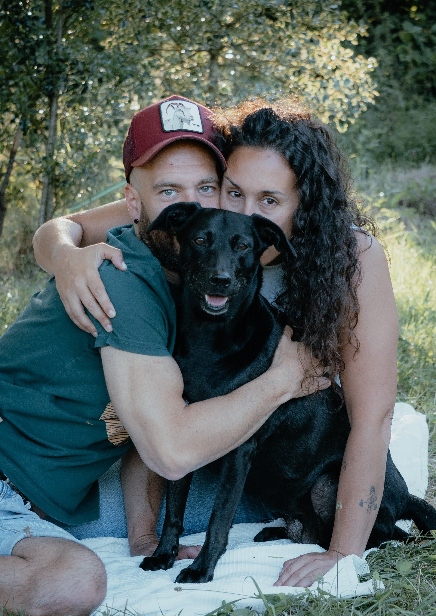 Una pareja abrazada junto a su perro