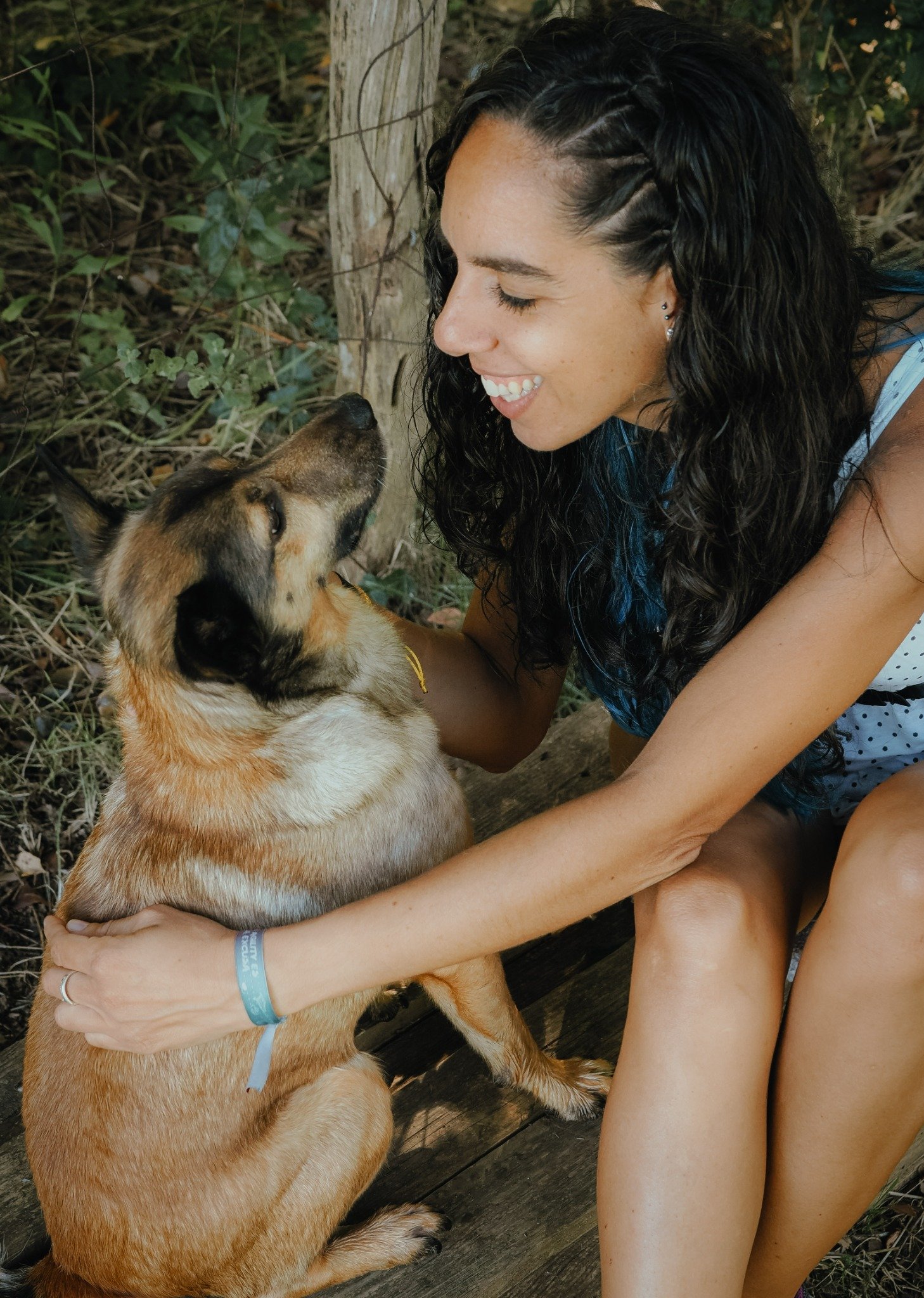 Una mujer y su perro se miran con complicidad en el monte